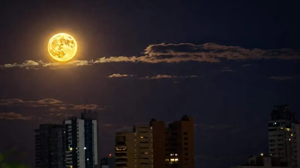 Lua dos Veados alaranjada encanta céu de Campo Grande