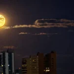 Lua dos Veados alaranjada encanta céu de Campo Grande
